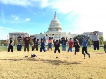 連邦議会議事堂前の広場でジャンプする生徒たち